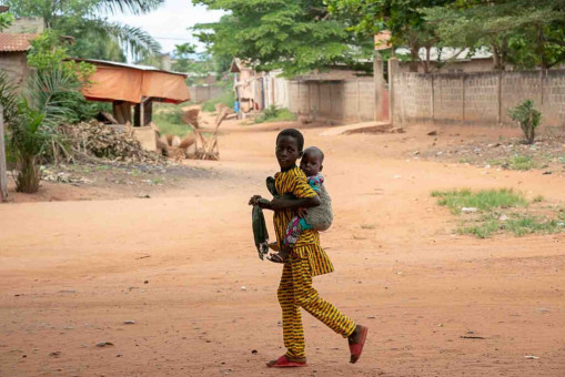 Un enfant portant son frère sur le dos